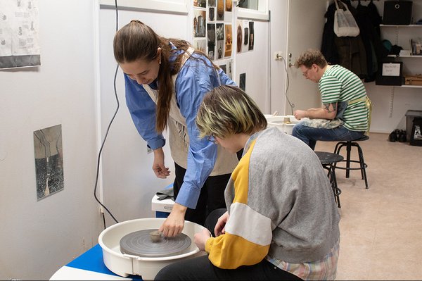 Keramikledaren Amalie Hissan hjälper en deltagare.