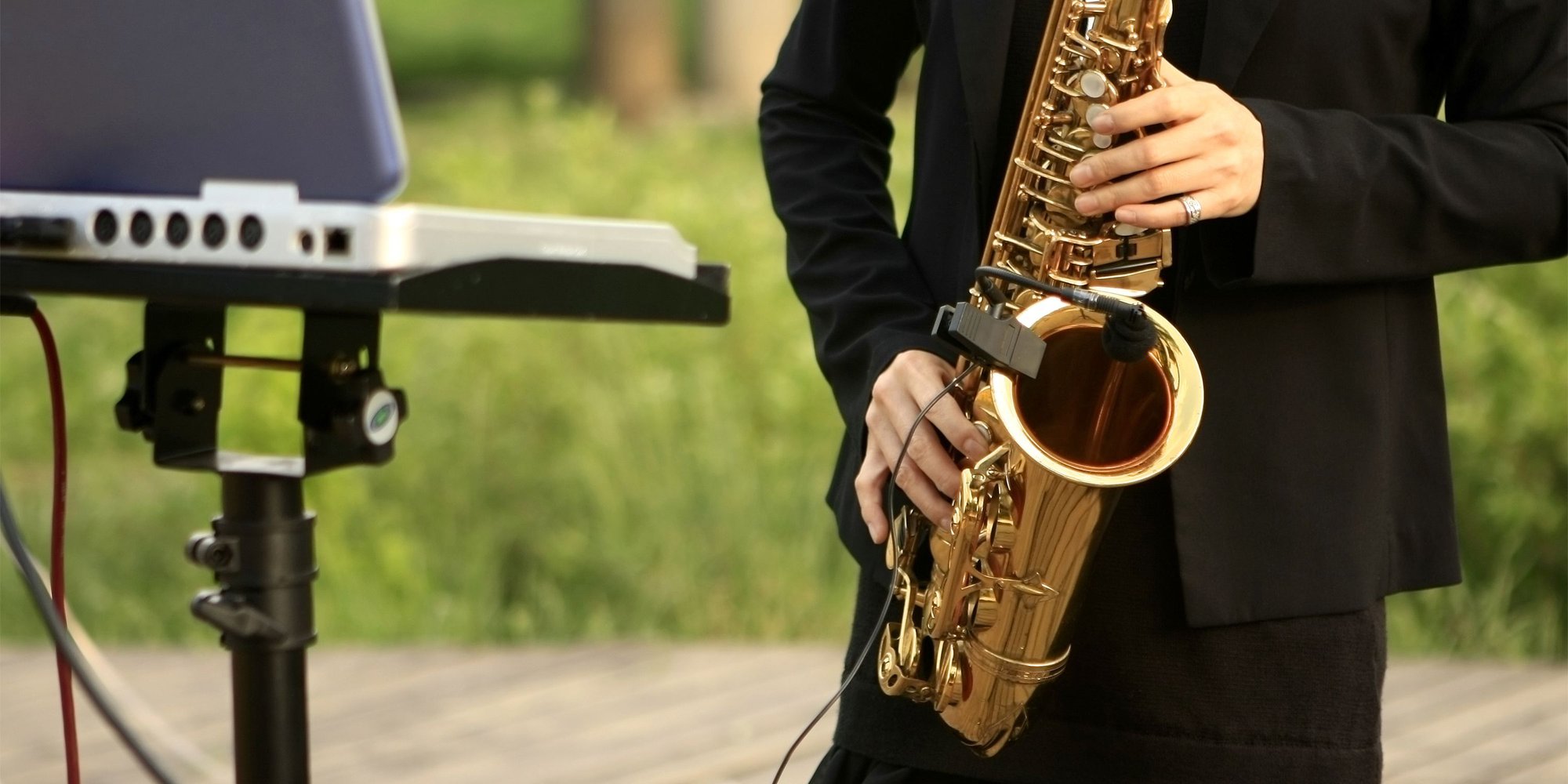 En man spelar saxofon i en park