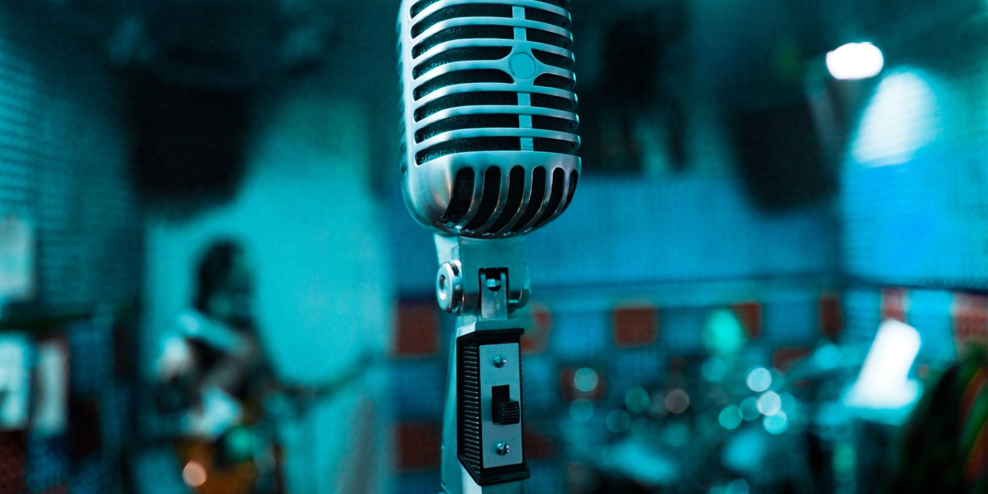 En mikrofon i förgrunden och en musiker i bakgrunden