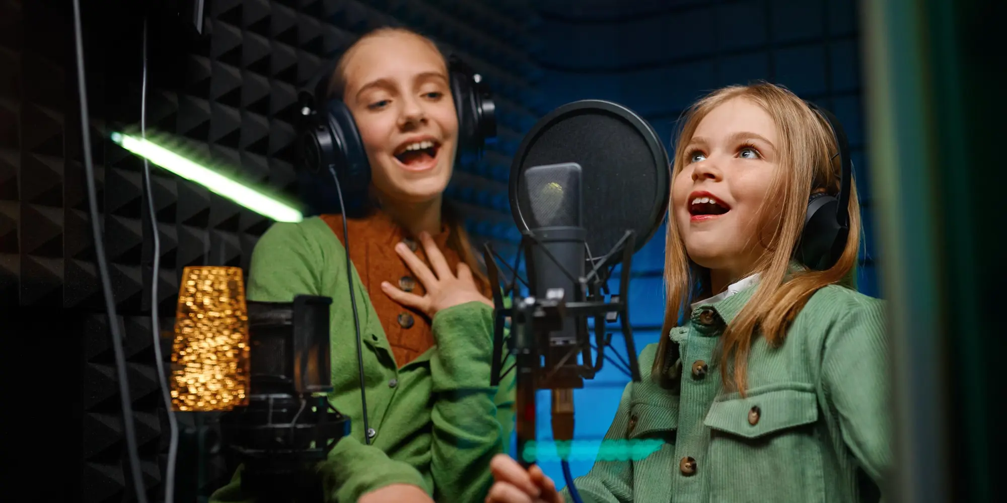 två tjejer som står i musikstudio och sjunger framför en mick