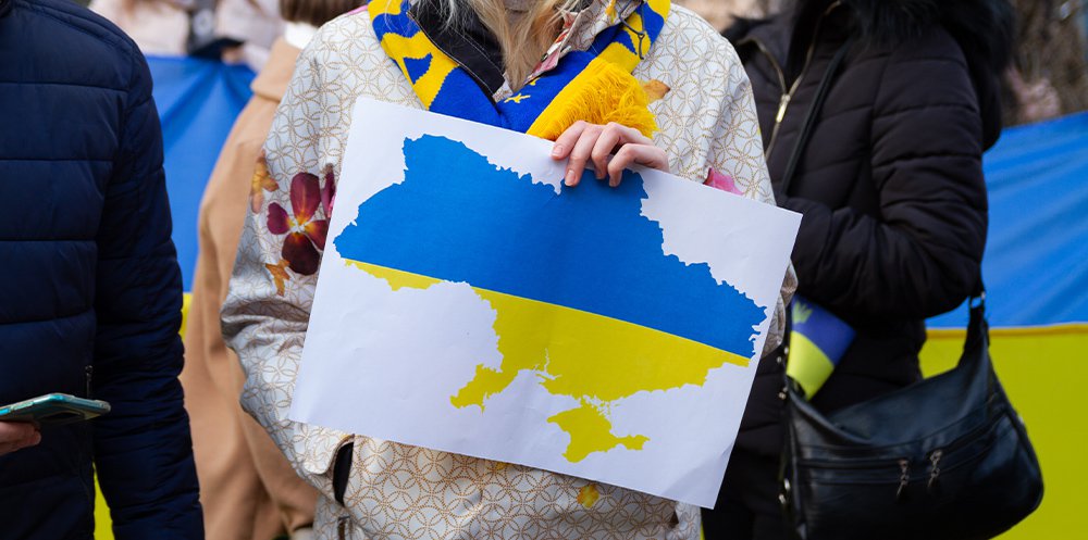 Kvinna med skylt med Ukrainas flagga