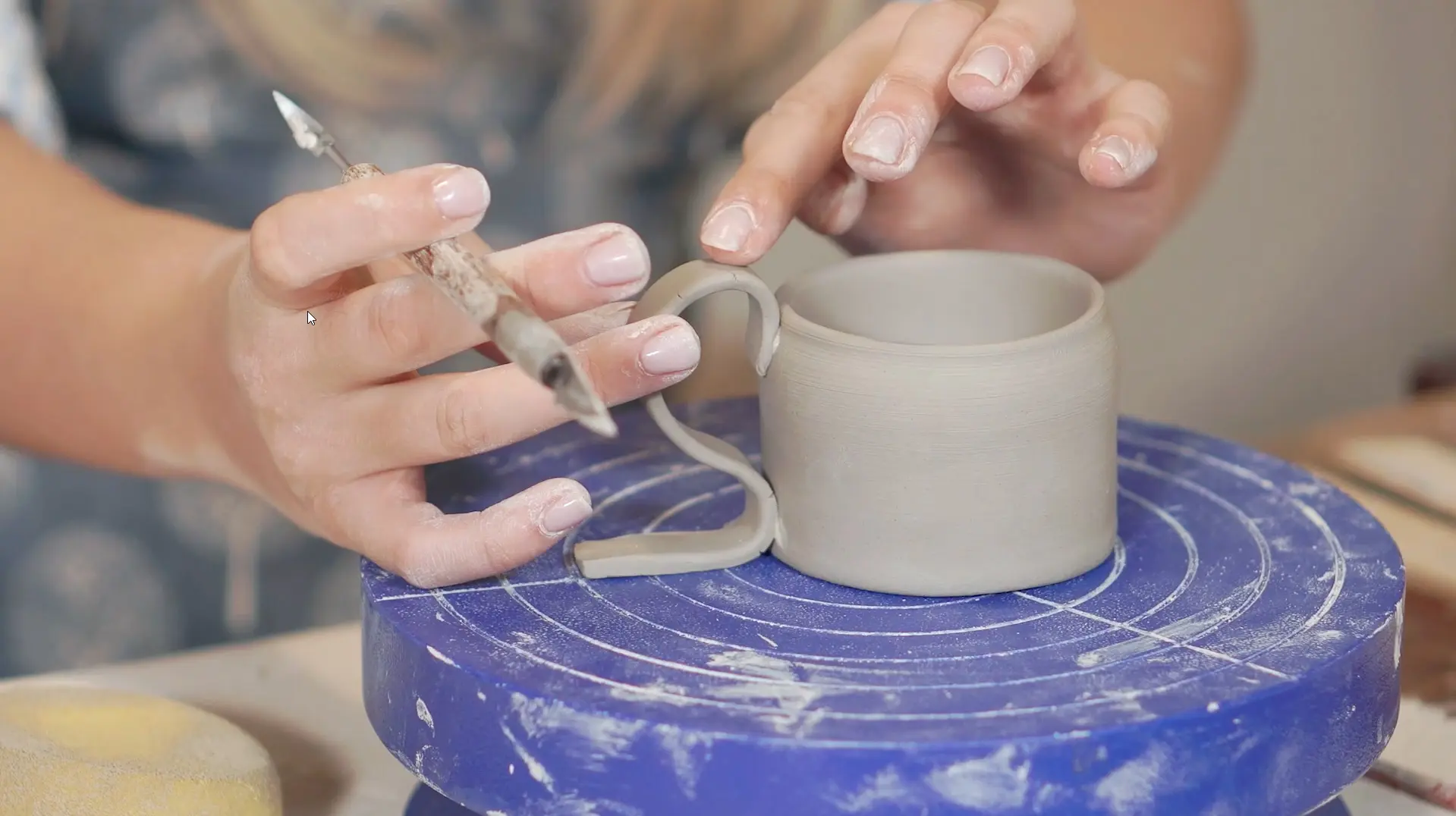 Person gör en kopp i keramik