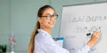 Kursledare undervisar i engelska vid whiteboard med texten "English lesson"