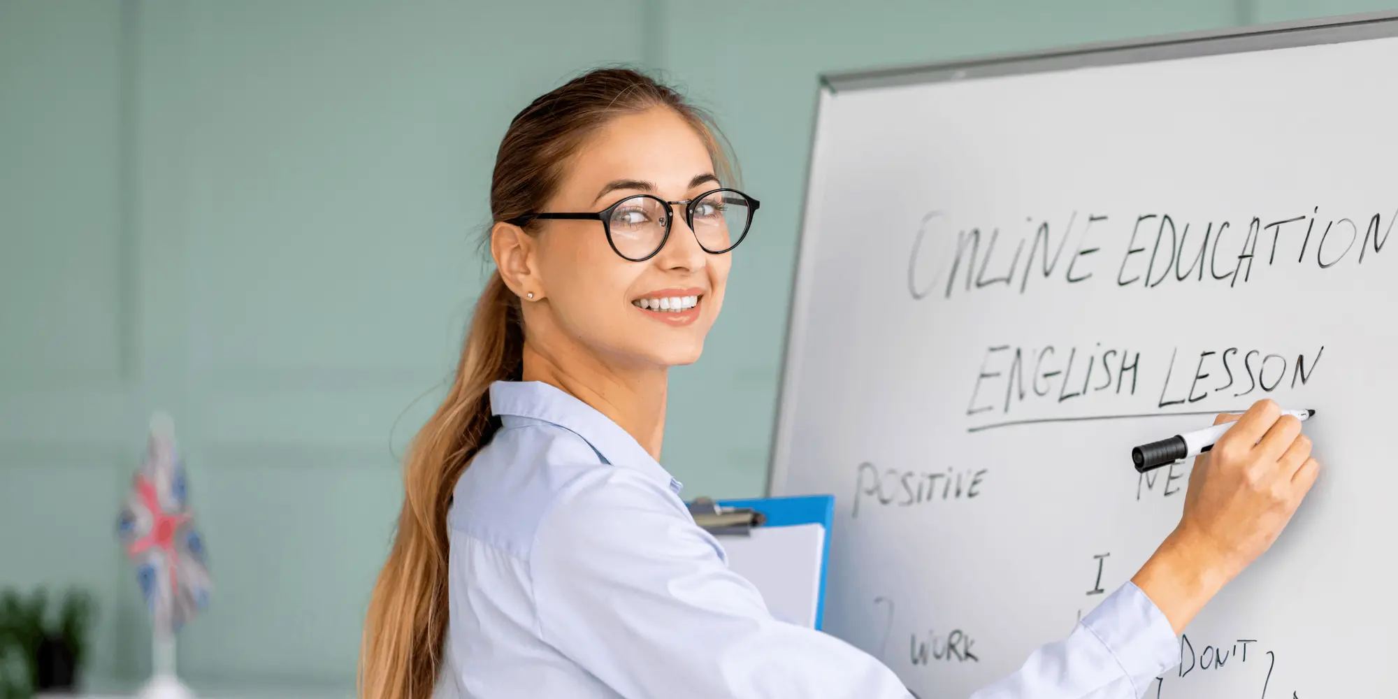 Kursledare undervisar i engelska vid whiteboard med texten "English lesson"