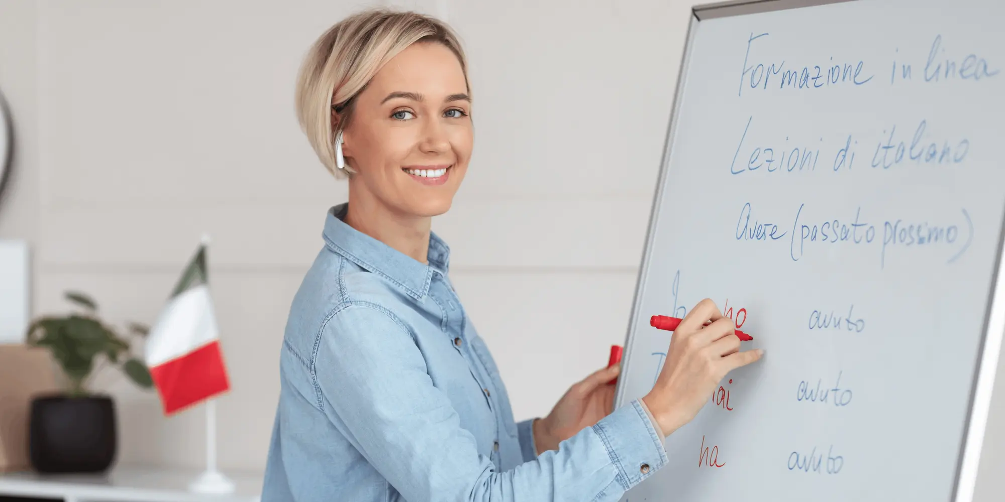 Språklärare undervisar i italienska vid whiteboard med grammatikövningar.