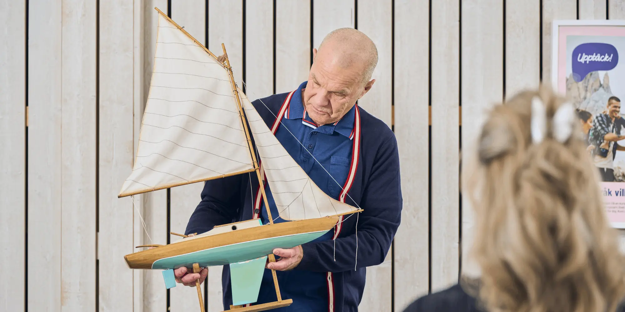 Kursledare visar upp en modellbåt under en sjölivskurs