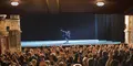 Publik applåderar entusiastiskt i en elegant teatersalong medan en dansare avslutar sitt nummer ensam på scenen