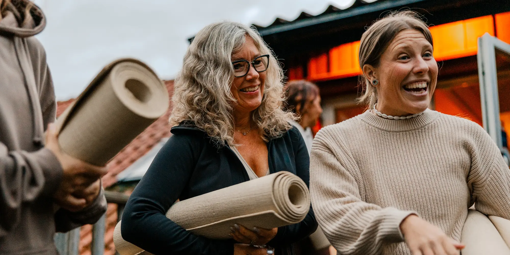 Kvinnor tillsammans med yogamattor i händerna