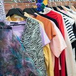 Färgglada kläder på en klädställning