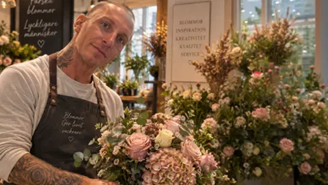 florist visar upp en bukett