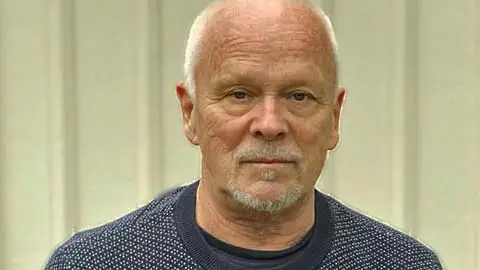 Kursledare Lars Melander står mot en husvägg och tittar in i kameran.