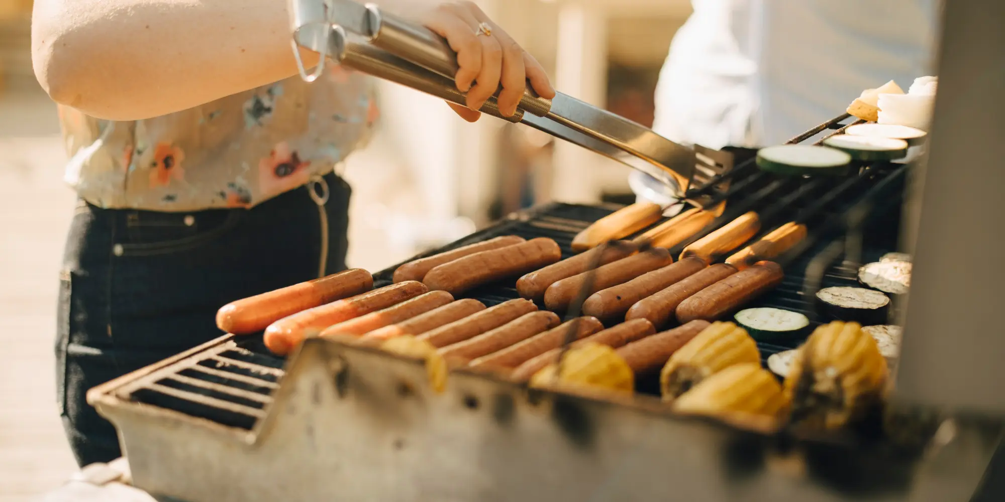 Person grillar korv på grill