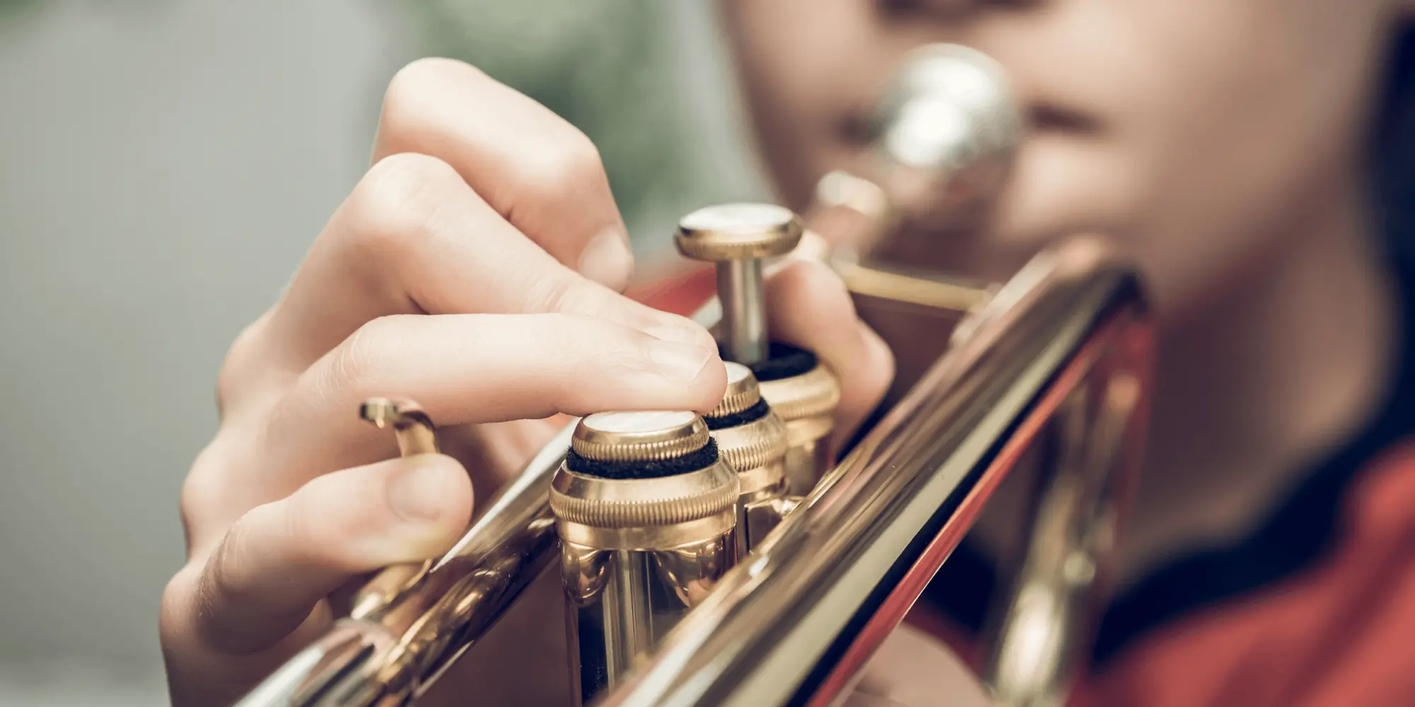 Närbild på en person som spelar trumpet